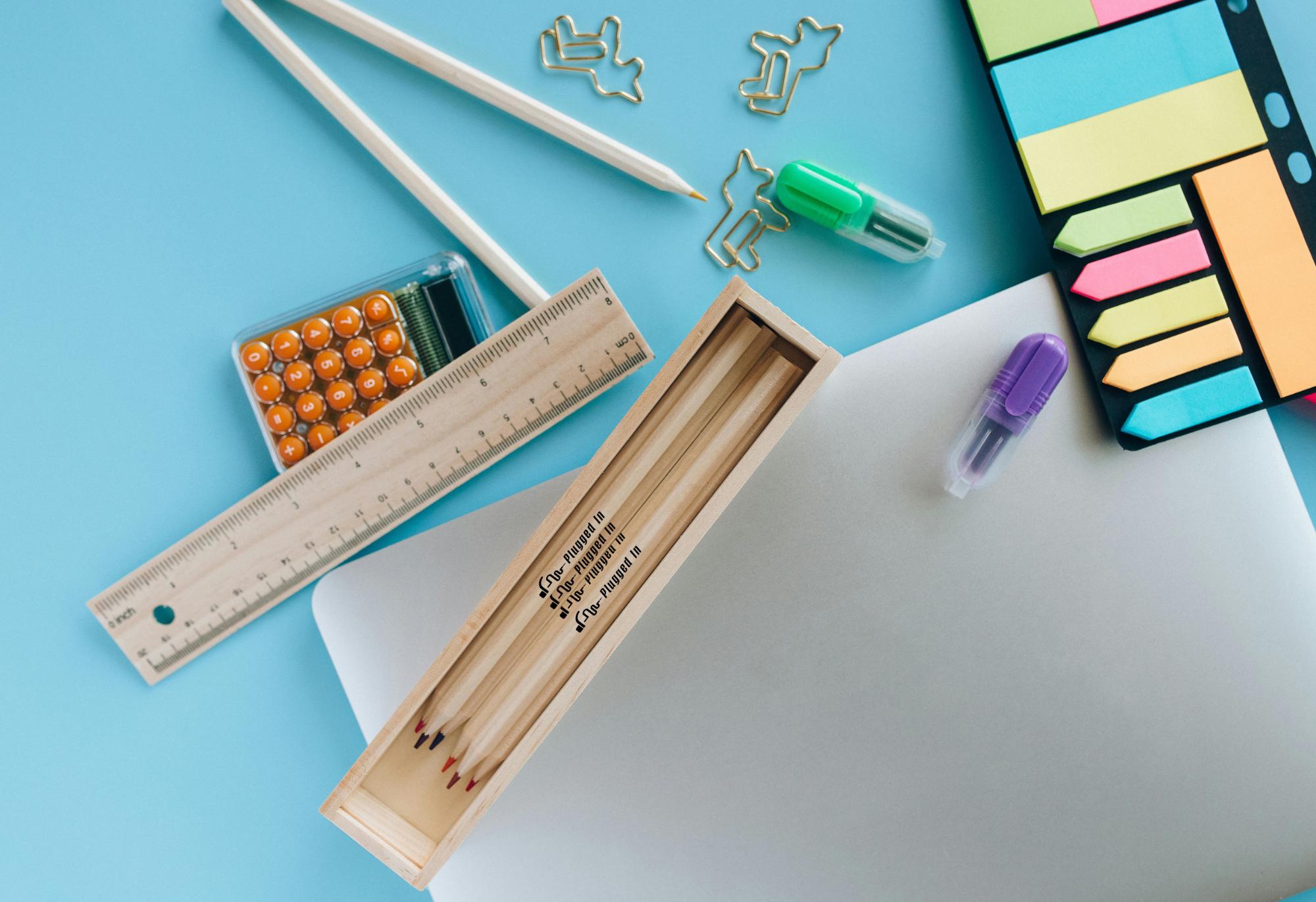 logo custom printed on colored pencils sitting on a table with other desk supplies